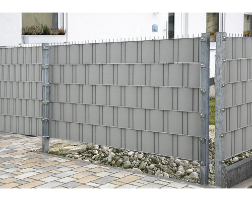 Clôture d''intimité en plastique avec poteaux métalliques dans le jardin