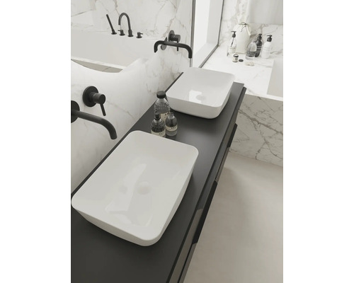 Salle de bains lumineuse avec deux vasques à poser sur un plan de toilette foncé et robinetterie