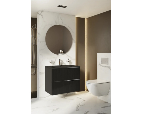 Salle de bains avec meuble sous-lavabo noir, miroir rond et WC suspendu.