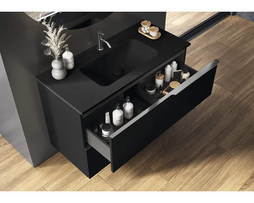 Meuble sous-lavabo noir avec tiroir ouvert dans la salle de bain