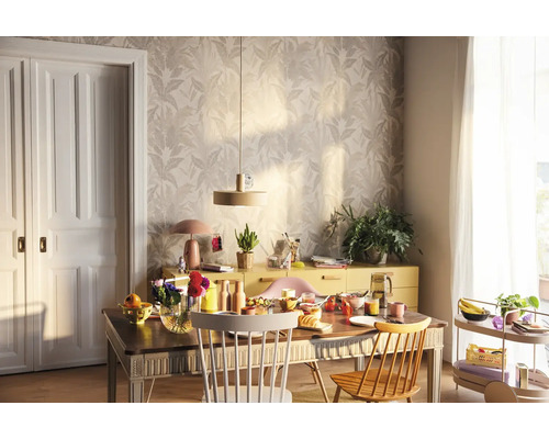 Salle à manger lumineuse avec table en bois, chaises, buffet et papier peint floral pour une ambiance conviviale.