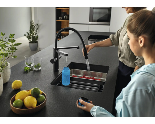 Cuisine moderne avec évier, robinet et deux personnes lavant des fruits