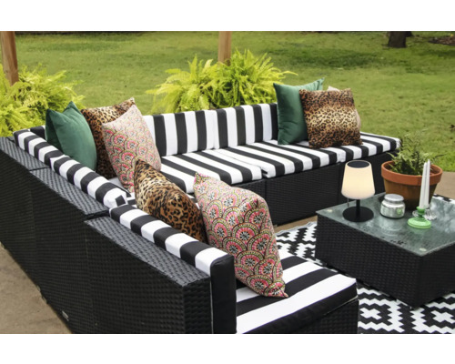 Gartenlounge mit gestreiften Auflagen und gemusterten Kissen auf Terrasse
