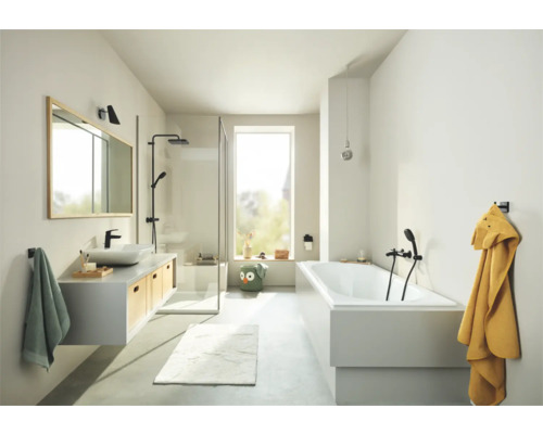 Salle de bains lumineuse avec lavabo, miroir, douche, baignoire et serviettes