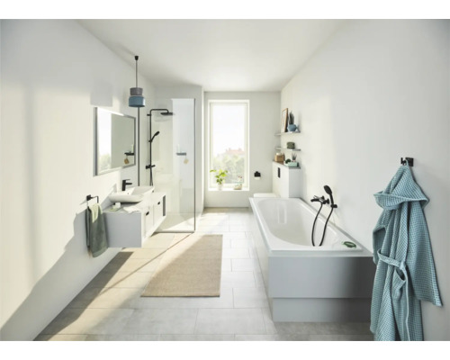 Salle de bain lumineuse avec douche, baignoire, lavabo et serviette