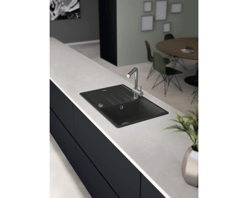 Schwarzes Spülbecken mit Wasserhahn auf einer Arbeitsplatte in der Küche.