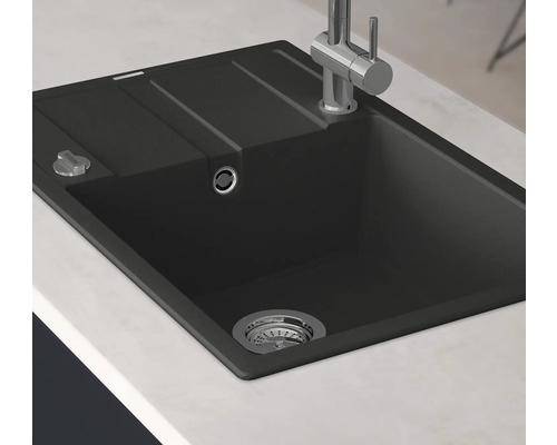 Schwarze Spüle mit Abtropffläche und Armatur auf einer Arbeitsplatte