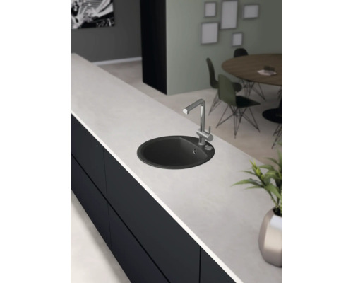 Küchenspüle mit Armatur auf einer Küchentheke in einem hellen und modernen Küchenraum.