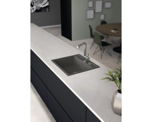 Scène de cuisine avec évier et robinet sur un plan de travail.