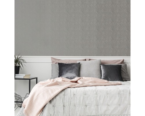 Chambre avec papier peint à structure grise sur le mur.