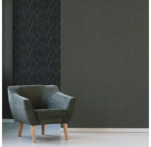 Décoration murale décorative avec un papier peint uni et un papier peint à motif de branches, combinée avec un fauteuil.