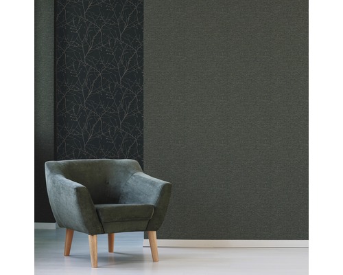 Décoration murale décorative avec un papier peint uni et un papier peint à motif de branches, combinée avec un fauteuil.