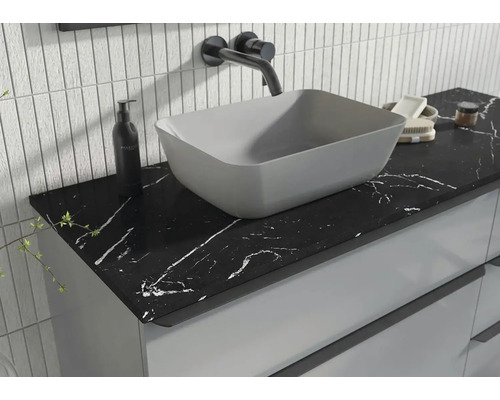 Salle de bains moderne avec lavabo à poser et plan de travail noir à motif marbré.