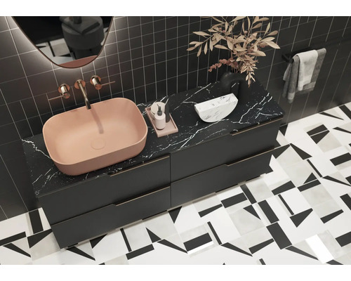 Salle de bains moderne avec lavabo à poser rose, meuble bas avec plateau en marbre et carrelage géométrique.