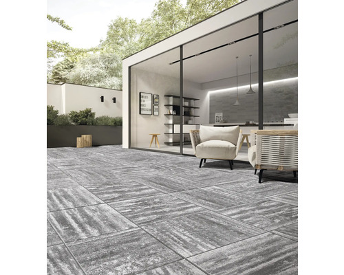 Terrasse avec dalles carrées en pierre, mobilier de jardin et maison moderne