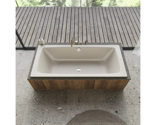 Baignoire intégrée avec robinetterie sur un revêtement en bois dans une salle de bains