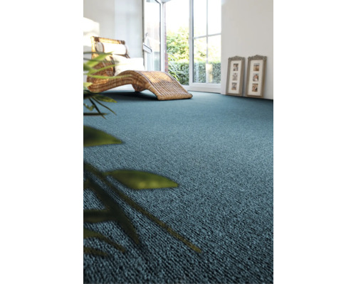 Scène avec moquette, chaise longue en osier et plante d'intérieur dans une pièce lumineuse