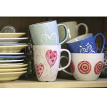 Gestapelte Tassen und Teller im Regal