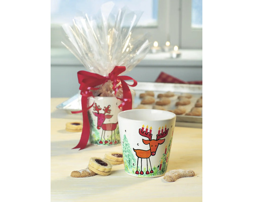 Zwei Keramiktassen mit Hirschmotiv und Weihnachtskekse.