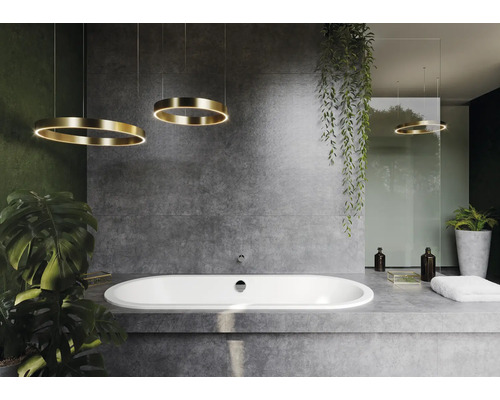 Badezimmer mit ovaler Badewanne, Betonwand und runden Hängeleuchten