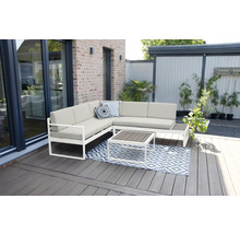 Salon de jardin avec canapé d''angle, table et tapis sur une terrasse