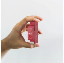 Eine Hand hält ein rotes Shelly-Gerät zur Hausautomation
