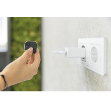 Une main tient un traceur carré, tandis qu''un chargeur est branché sur une prise