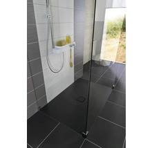 Douche à l''italienne avec caniveau de douche, robinetterie de douche et paroi en verre dans une salle de bains au design moderne.