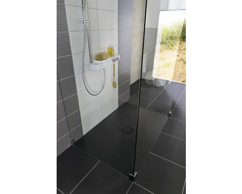 Douche à l''italienne avec caniveau de douche, robinetterie de douche et paroi en verre dans une salle de bains au design moderne.