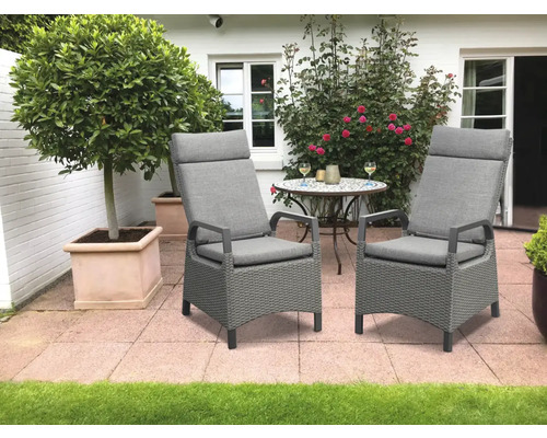 Deux chaises de jardin grises avec de hauts dossiers et des coussins sur une terrasse