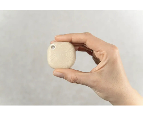 Hand hält einen Tracker mit Loch für einen Schlüsselanhänger