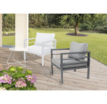 Scène de jardin avec un fauteuil lounge blanc et gris et une table d''appoint sur une terrasse