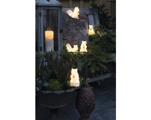 Scène décorative avec figurines d''écureuils lumineux, lanterne et jardinière sur un banc