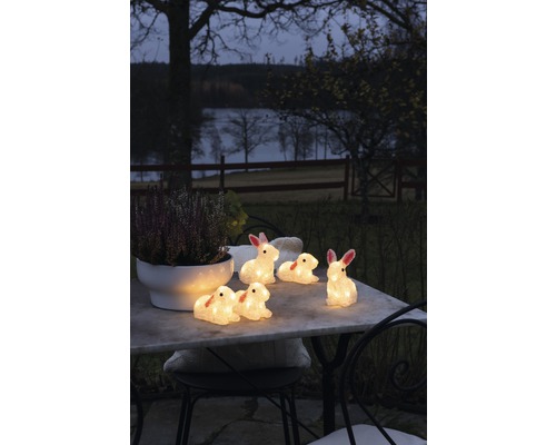 Figurines décoratives de lapins avec éclairage sur une table de jardin