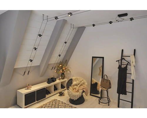 Schlafzimmer mit Dachschräge, ausgestattet mit einem flexiblen Seilsystem zur Beleuchtung.