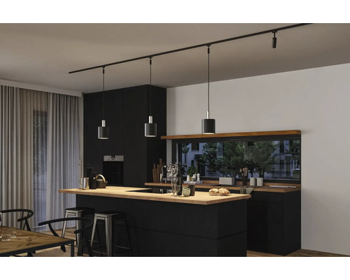 Cuisine moderne avec îlot de cuisine noir, plan de travail en bois et système de rails noir avec trois suspensions