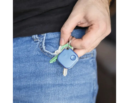 Eine Hand steckt einen Schlüsselfinder zusammen mit Schlüsseln in die Hosentasche