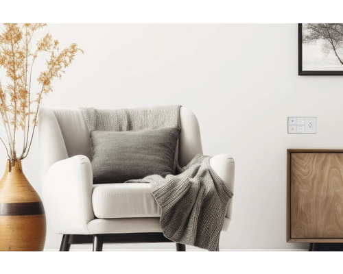 Wohnzimmer mit Sessel, Kissen, Decke, Vase und Schalter