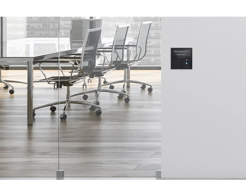 Salle de réunion avec table, chaises et système de réservation de salle