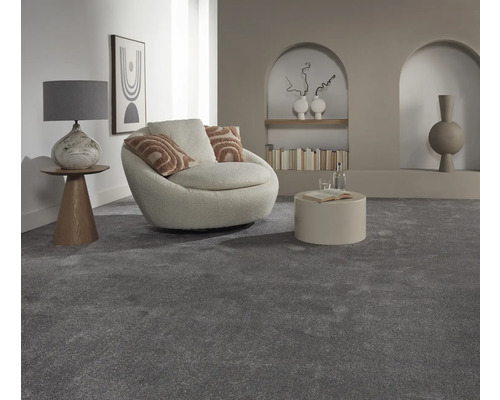 Wohnzimmer mit grauem Teppich, Sessel und Beistelltisch