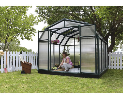 Serre de jardin avec une femme qui entretient les plantes