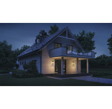 Modernes Haus mit Balkon und Garten bei Nacht