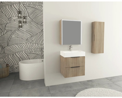 Badezimmer mit Waschtisch, Spiegel, Hochschrank und Badewanne vor einer gemusterten Tapete.