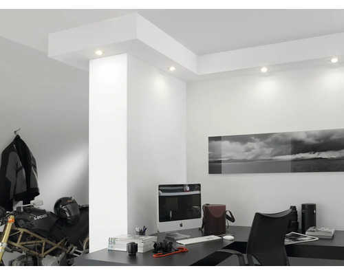 Pièce lumineuse avec bureau, ordinateur, moto et spots encastrés au plafond