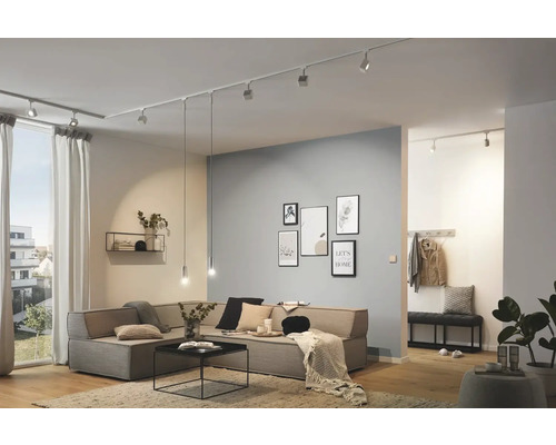 Wohnzimmer mit Beleuchtungssystem an der Decke, Ecksofa und Dekoration