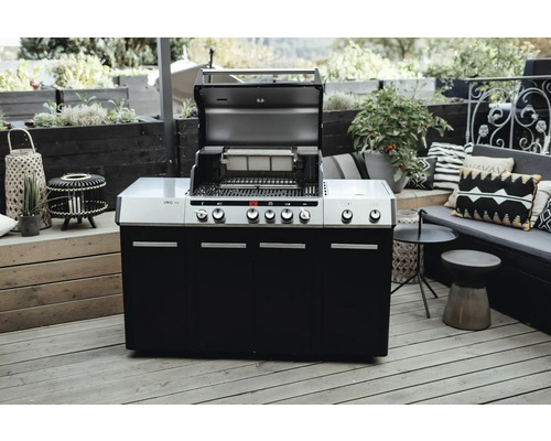 Gril à gaz avec couvercle ouvert sur une terrasse.