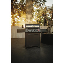 Barbecue à gaz gris foncé avec cinq brûleurs sur une terrasse extérieure.