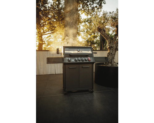 Barbecue à gaz gris foncé avec cinq brûleurs sur une terrasse extérieure.