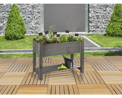 Jardinière sur pieds en bois avec herbes aromatiques et outils de jardin