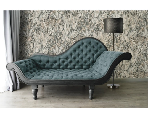 Chaiselongue mit Samtbezug vor einer gemusterten Tapete und Stehlampe